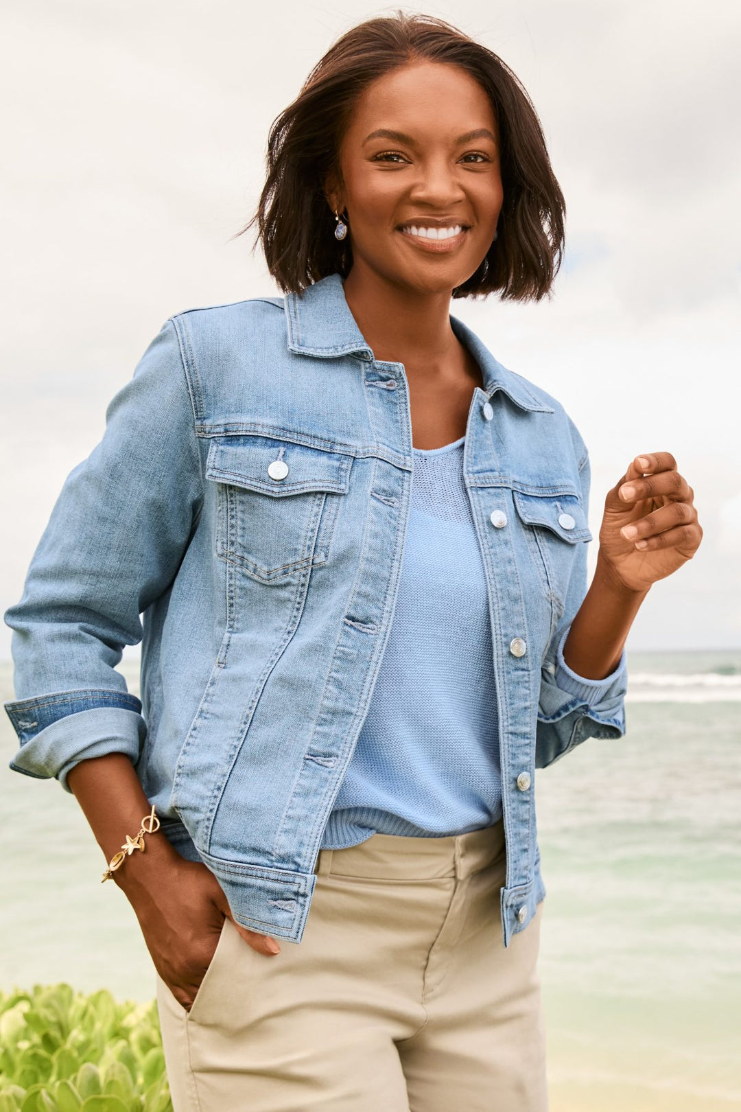 Woman wearing a Tommy Bahama denim jacket with a blurred natural background