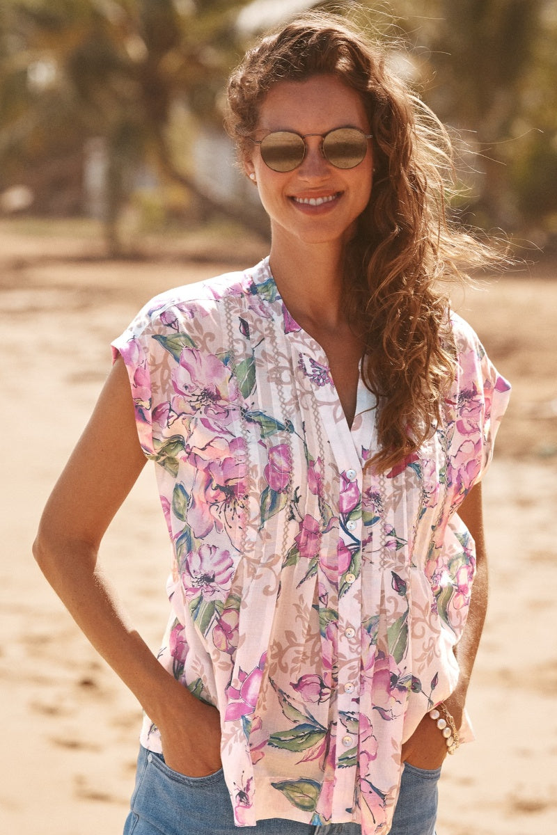 Woman wearing a floral shirt and sunglasses outdoors